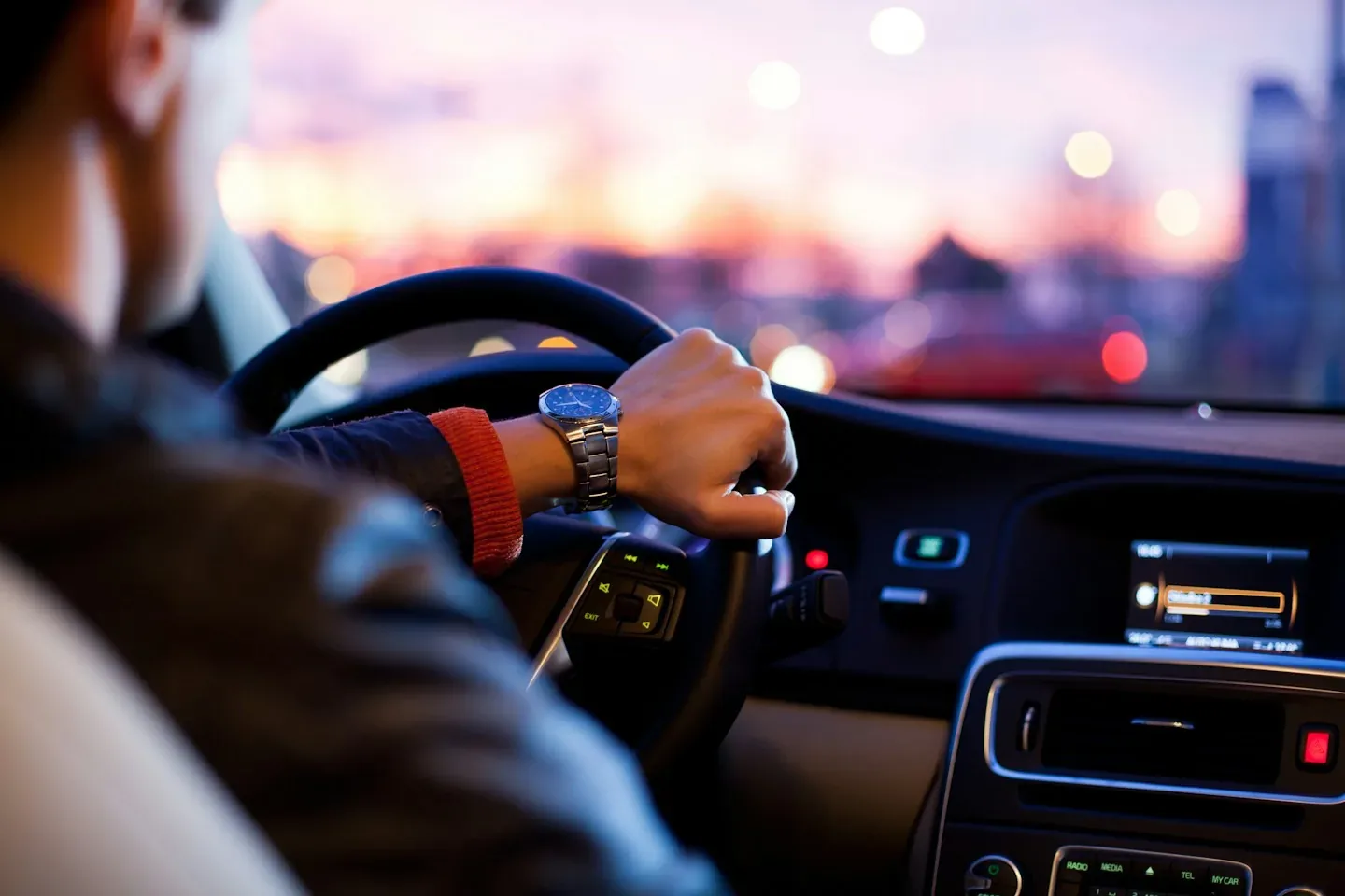 A driver at the wheel of a car on a city street