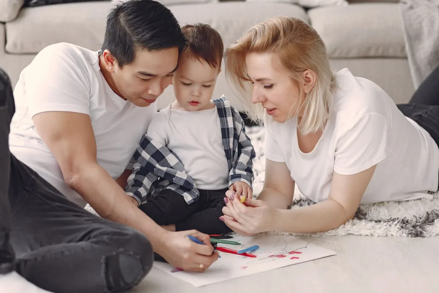 Parents drawing with their young child at home