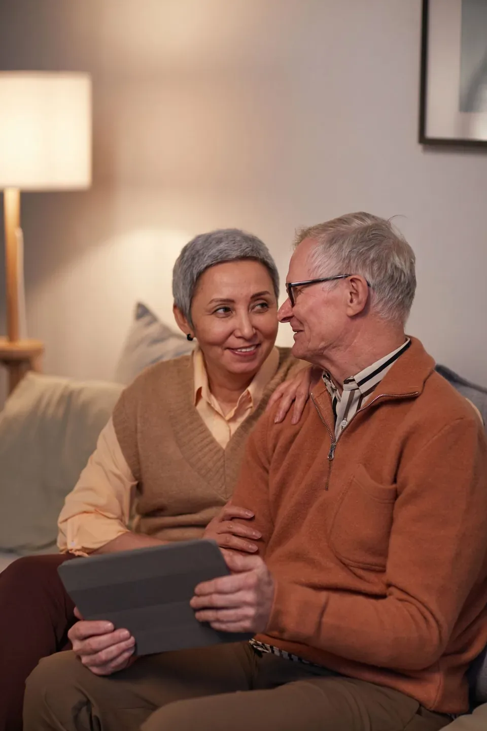 An older couple sitting close together at home
