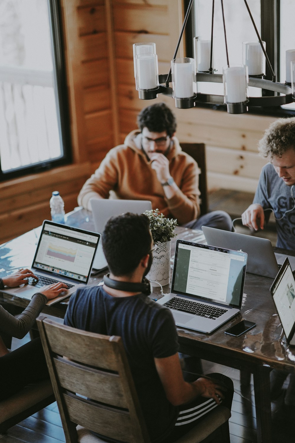 Illustrative workplace scene of colleagues working on laptops around a shared table